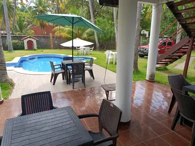 a patio with a table and chairs and a pool at Rancho villas de alicia in La Paz