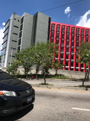 a black car parked in front of a large building at APARTAMENTO CON LA MEJOR VISTA DE SAN SALVADOR in San Salvador