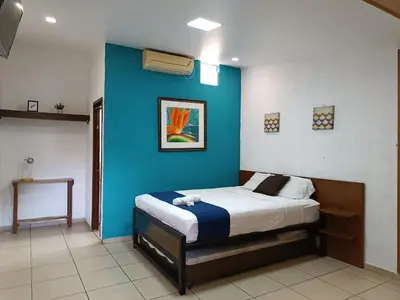 a bedroom with a blue wall and a bed at El Patio de Don Moncho in Nueva San Salvador