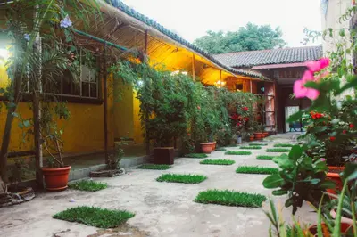 a courtyard with potted plants and a yellow building at El Patio de Don Moncho in Nueva San Salvador
