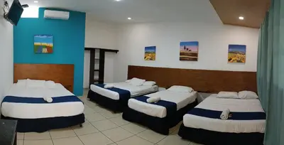 a room with three beds in a room at El Patio de Don Moncho in Nueva San Salvador