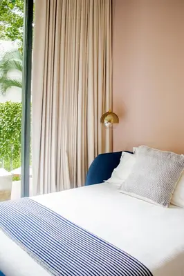 a bed with a blue chair and a window at Il Buongustaio in San Salvador