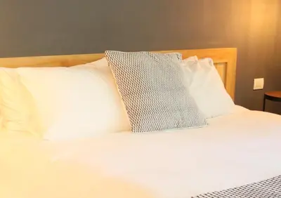 a bed with white sheets and pillows at Il Buongustaio in San Salvador