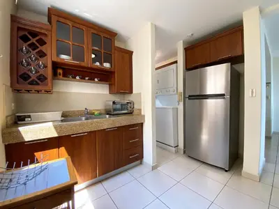 a kitchen with wooden cabinets and a stainless steel refrigerator at Beautiful apartment, Terrace with incredible view, 3 bdr, Escalon, Exclusive, Secure in San Salvador
