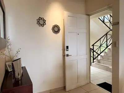 a hallway with a white door and a staircase at Beautiful apartment, Terrace with incredible view, 3 bdr, Escalon, Exclusive, Secure in San Salvador