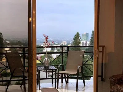a balcony with two chairs and a table with a view at Beautiful apartment, Terrace with incredible view, 3 bdr, Escalon, Exclusive, Secure in San Salvador