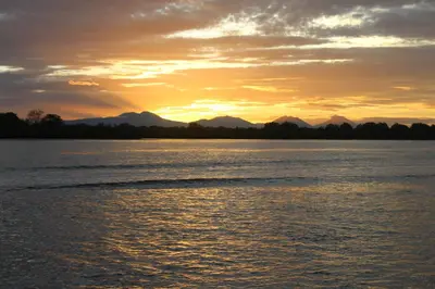 a sunset over the water with mountains in the background at Hotel Bahia del Sol in La Herradura