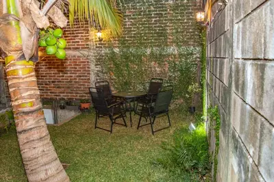 a patio with a table and chairs and a palm tree at Mixtepek in Juayúa