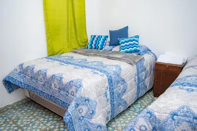 a bedroom with two beds with blue and white sheets at Mixtepek in Juayúa