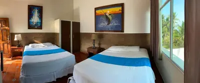 a bedroom with two beds and a window at Konchamar in La Libertad