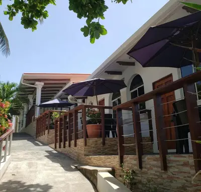a restaurant with blue umbrellas on the side of a building at Konchamar in La Libertad