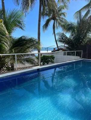 a blue swimming pool with palm trees in the background at Konchamar in La Libertad