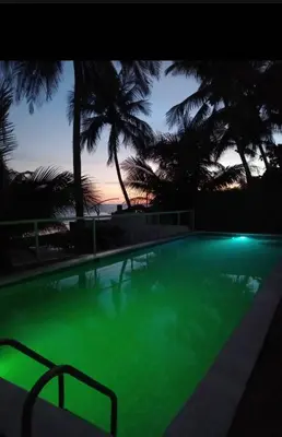 a large swimming pool with green illumination at dusk at Konchamar in La Libertad
