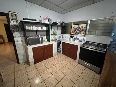 a kitchen with a stove and a counter top at Nanda Parbat Hostal in San Rafael Cedros