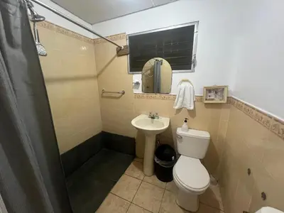 a bathroom with a toilet and a sink at Nanda Parbat Hostal in San Rafael Cedros