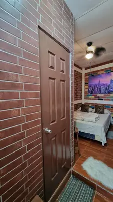 a brick wall with a door leading to a bedroom at Hostal Las Veraneras Ataco in Concepción de Ataco