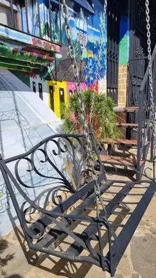 a metal bench with plants in front of a building at Hostal Las Veraneras Ataco in Concepción de Ataco