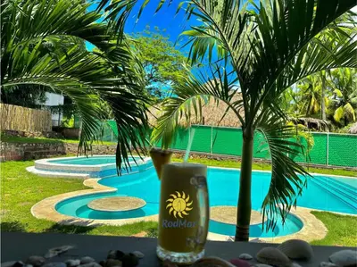 a drink sitting on a table next to a pool at RodMar Hotel in El Cuco