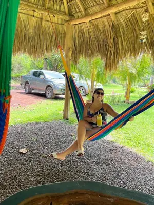 a woman in a bikini sitting on a hammock at RodMar Hotel in El Cuco