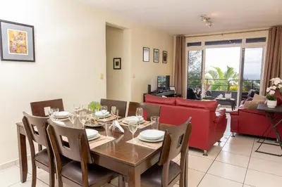 a dining room with a table and a red couch at Luxury Modrn Apartment, w/amazing view, 3BR,Escalon,Exclus,Secur in San Salvador