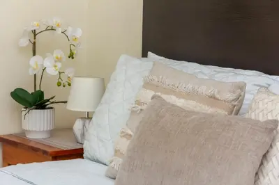 a bedroom with a bed with pillows and a table with a lamp at Luxury Modrn Apartment, w/amazing view, 3BR,Escalon,Exclus,Secur in San Salvador