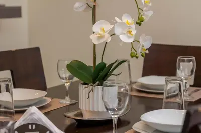 a table with a vase with white flowers on it at Luxury Modrn Apartment, w/amazing view, 3BR,Escalon,Exclus,Secur in San Salvador