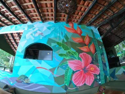 a wall with a painting of flowers on it at Lagarza Hostel in La Libertad