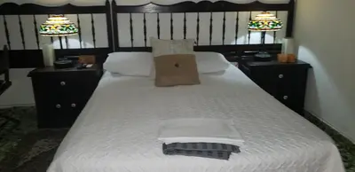 a bedroom with a bed with a bag on it at Mendoza’s Guest House in Santa Ana