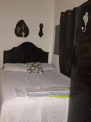 a bed with a wooden headboard in a bedroom at Mendoza’s Guest House in Santa Ana