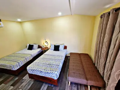 two beds in a room with yellow walls at Hostal Juarez Ataco in Concepción de Ataco