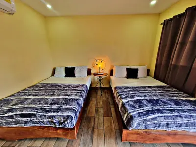 two beds sitting next to each other in a room at Hostal Juarez Ataco in Concepción de Ataco