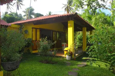 a yellow house in a yard with a grass yard at Thermal Paradise Villa in Caluco