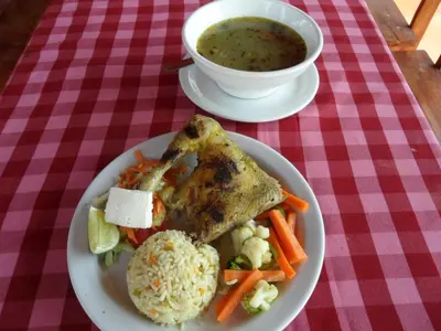 a plate of food with chicken and vegetables and a bowl of soup at Thermal Paradise Villa in Caluco