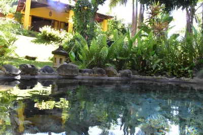 a swimming pool in front of a house at Thermal Paradise Villa in Caluco