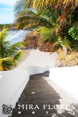 a stairway leading down to a beach with palm trees at Hotel Miraflores in El Cuco