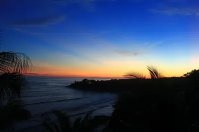 a sunset over a beach with the ocean at Hotel Miraflores in El Cuco