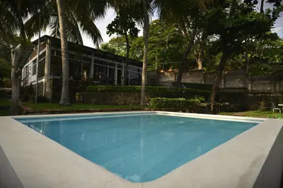 a swimming pool in front of a building at RocaSol Casa d´Mar in El Zonte