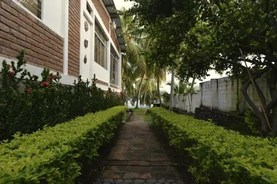 a walkway in front of a building with bushes at RocaSol Casa d´Mar in El Zonte