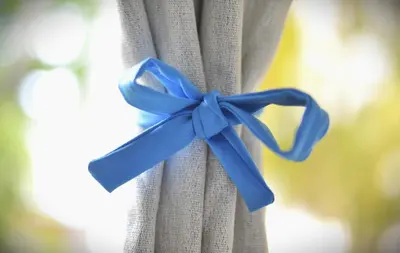 a blue ribbon is tied around a curtain at RocaSol Casa d´Mar in El Zonte