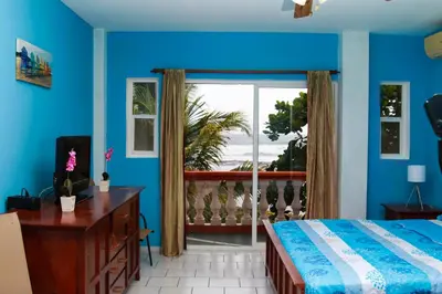 a bedroom with a bed and a view of the ocean at Sabas Beach Resort in La Libertad