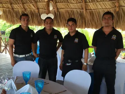 a group of men standing in front of a table at Sabas Beach Resort in La Libertad