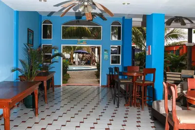 a restaurant with blue walls and tables and chairs at Sabas Beach Resort in La Libertad