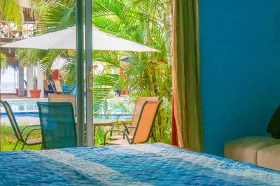 a bedroom with a table and chairs and an umbrella at Sabas Beach Resort in La Libertad