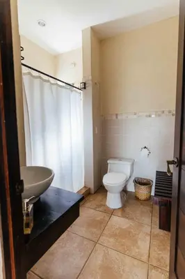 a bathroom with a toilet and a sink at Casa 1800 Ataco Hotel Boutique in Concepción de Ataco