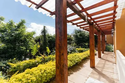 a wooden pergola with a view of a garden at Casa 1800 Ataco Hotel Boutique in Concepción de Ataco