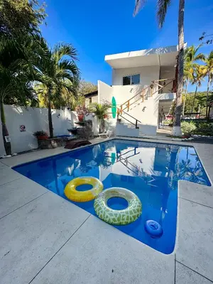a swimming pool with two inflatable rings in it at The Beach Break Hotel El Zonte in El Zonte