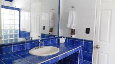 a blue tiled bathroom with a sink and a mirror at Las Veraneras Villas & Resort in Acajutla