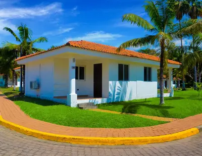 a small white house with a red roof at Las Veraneras Villas & Resort in Acajutla