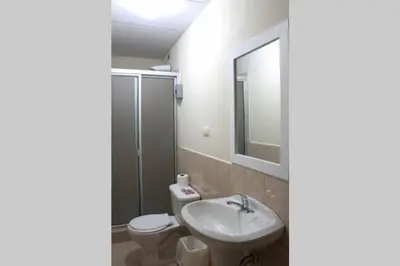 a bathroom with a sink and a toilet and a mirror at Casa Central completa in Santa Ana