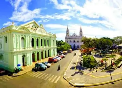 a street with cars parked in front of a building at Casa Central completa in Santa Ana